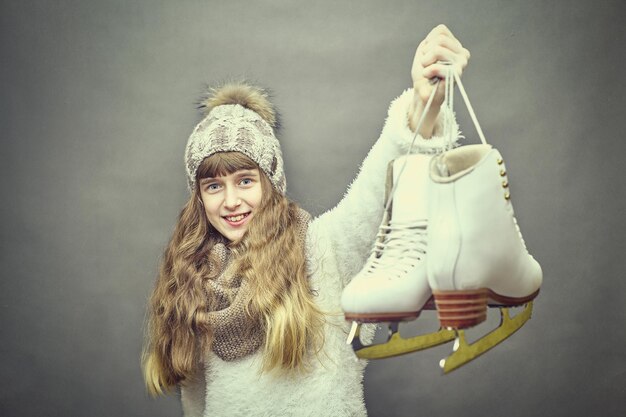 Jong mooi meisje met schaatsen op de achtergrond.