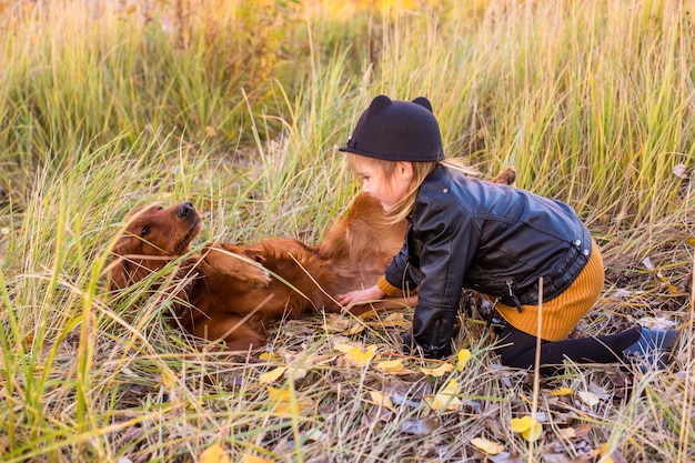 Jong mooi meisje speelt met haar hond in park