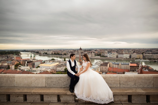 Jong mooi modieus paar jonggehuwden die door het Bastion van de Visser in Boedapest, Hongarije zitten