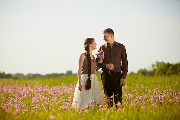 Jong mooi paar in een veld met bloemen