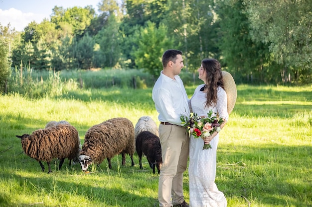 Jong mooi paar verliefd in trouwjurken staande op een groen weidevee op de achtergrond