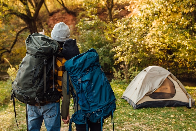 Jong mooi stel met wandelrugzakken komt terug van trekking