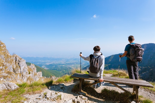 Jong paar bovenop berg die de horizon bekijken. Berg panorama