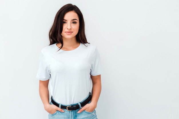 Jong positief donkerbruin meisje met lang haar die t-shirt en jeans dragen