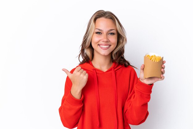 Jong Russisch meisje met gebakken chips geïsoleerd op een witte achtergrond, wijzend naar de zijkant om een product te presenteren