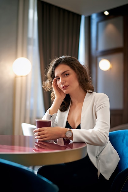 Jong schattig meisje koffie drinken in café