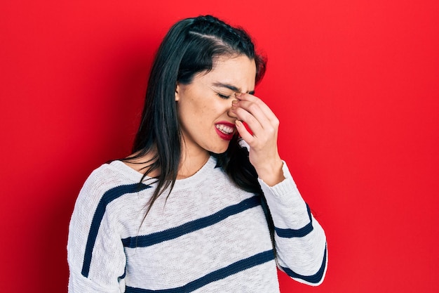 Jong spaans meisje dat casual kleding draagt, moe wrijft over neus en ogen die vermoeidheid en hoofdpijn voelen. stress en frustratie concept.