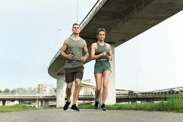 Jong sportief paar tijdens joggingtraining op stadsstraat