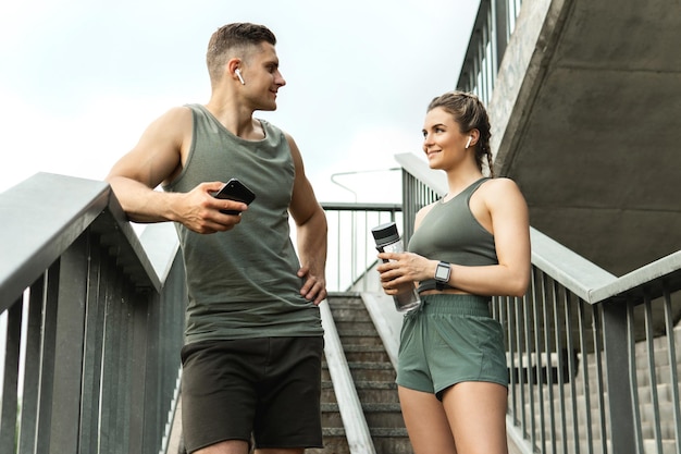 Jong sportief stel ontspannen na fitnesstraining buitenshuis