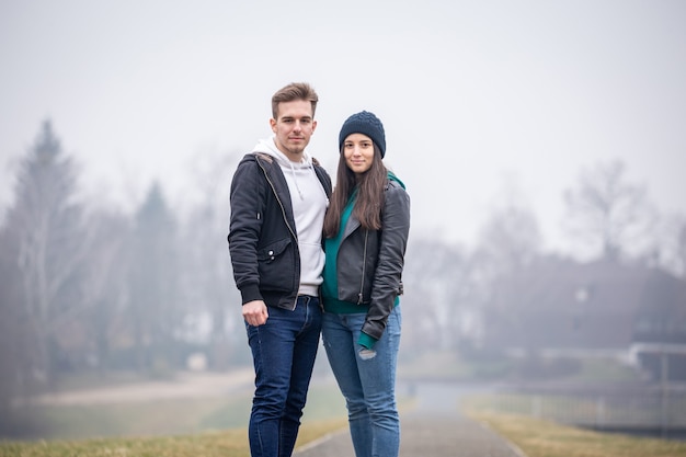 Foto jong stel brengt samen tijd door aan het gebartmeer op een mistige winterdag in zalaegerszeg, hongarije