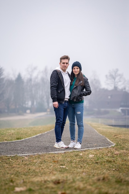 Jong stel brengt samen tijd door aan het gebartmeer op een mistige winterdag in zalaegerszeg, hongarije