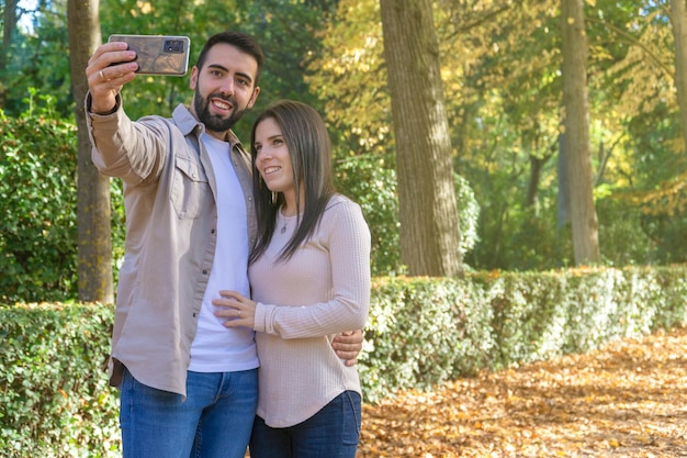 Jong stel dat een selfie maakt in een herfstpark