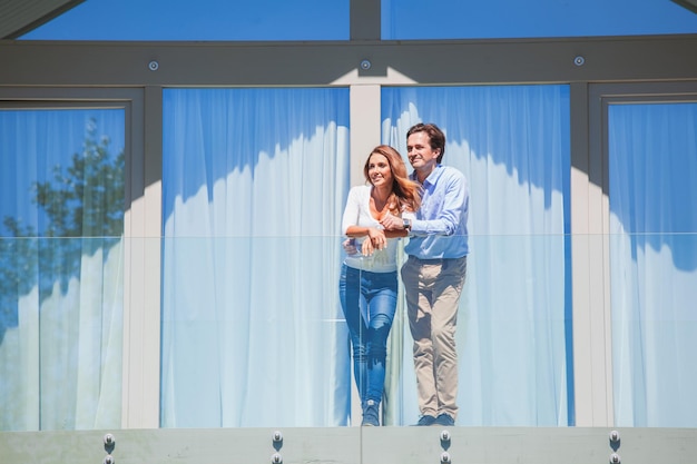 Jong stel dat samen op het balkon van hun huis staat