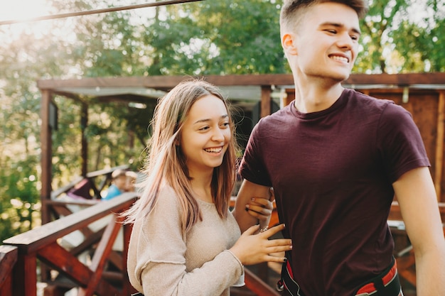 Jong stel dat veiligheidsharnassen draagt voor extreme vermakelijke rit in zomerpark en wegkijken