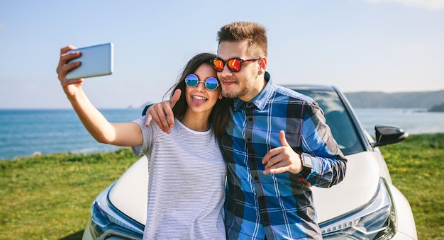 Foto jong stel doet een selfie op de auto