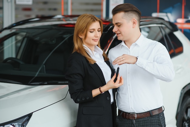 Foto jong stel door een auto in een autoshowroom te bouwen