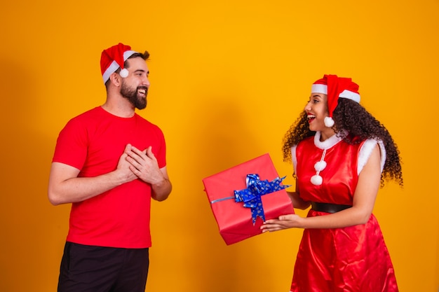 Jong stel geliefden die geschenken uitwisselen met Kerstmis. Vrolijk Kerstfeest