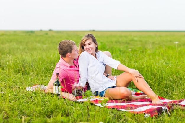 Jong stel in de zomerweide, man en vrouw die romantische picknick hebben.