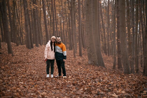 Jong stel in het herfstbos Man en vrouw in een relatie hebben een geweldige tijd buitenshuis