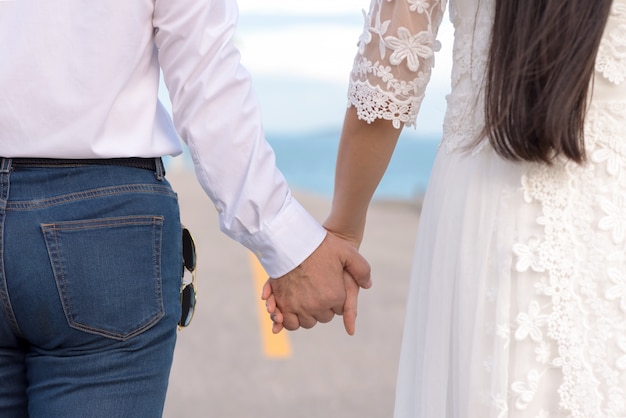 Jong stel in liefde houden handen in de zee kijken