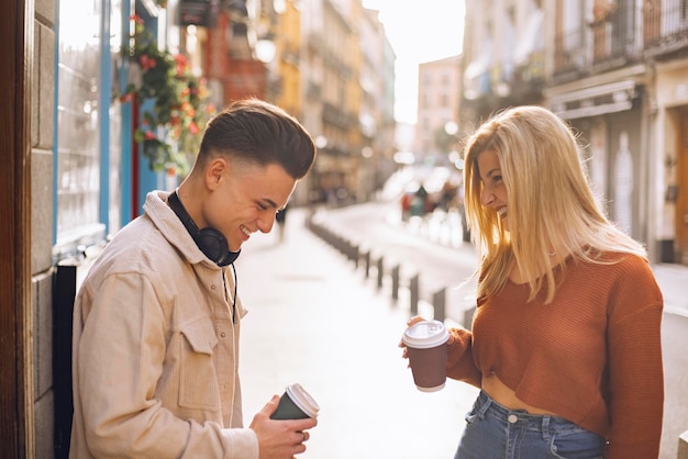 Jong stel lacht verliefd in de stad Ze houden koffie om te gaan