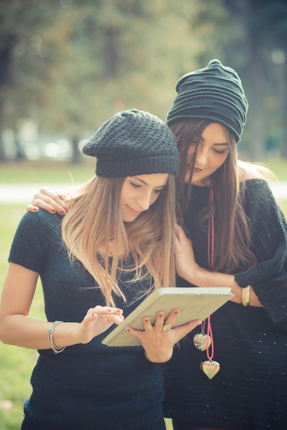 Foto jong stel mooie vrouwen meisjes herfst met behulp van tablet pc