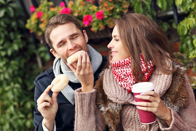 jong stel op date in de stad met koffie en donuts