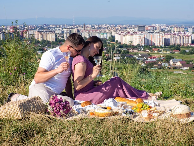 Jong stel picknickt bij het uitzicht op de stad