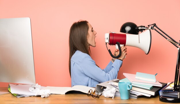 Jong studentenmeisje dat door een megafoon schreeuwt