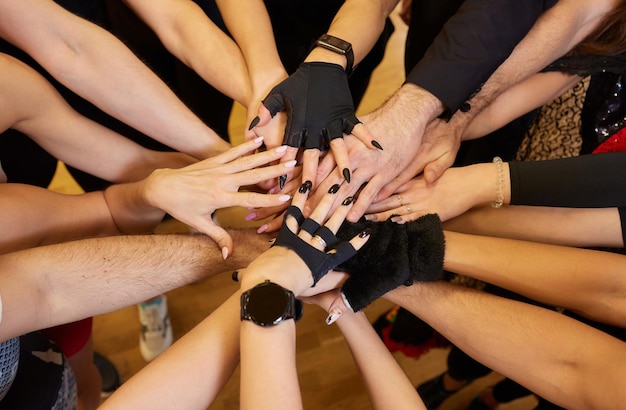 Jong team stapelt de handen op elkaar voor teambuilding en teamontwikkeling