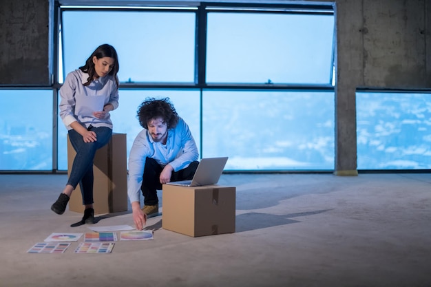 jong team van zakenmensen in groep, architect en ingenieur op bouwplaats die documenten en zakelijke workflow controleren met behulp van laptopcomputer in nieuw startkantoor