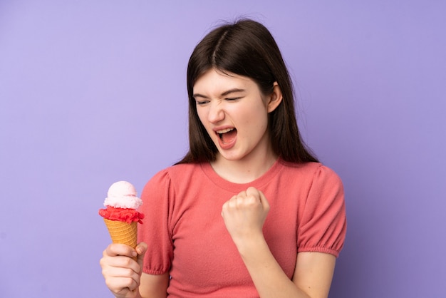 Jong tienermeisje dat een kornetijs over purpere muur houdt die een overwinning viert