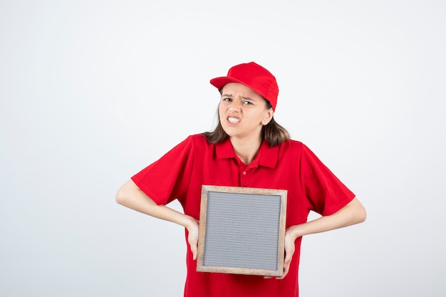 jong tienermeisje in rood uniform staan ?? en houden frame