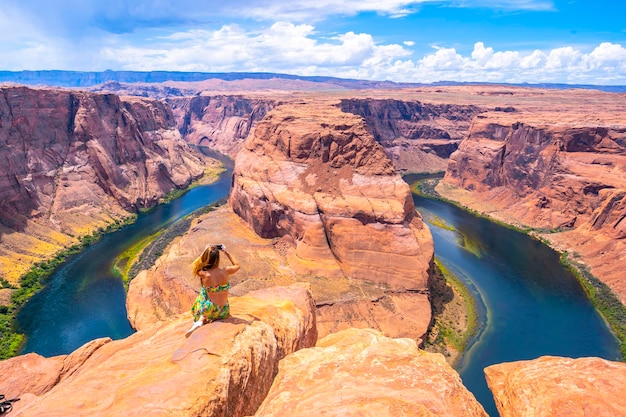 Jong toeristisch meisje met groene jurk in horseshoe bend, arizona, verenigde staten