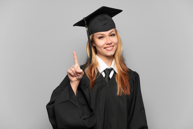 Jong universitair gediplomeerd meisje over geïsoleerde achtergrond die en een vinger in teken van het beste tonen opheft