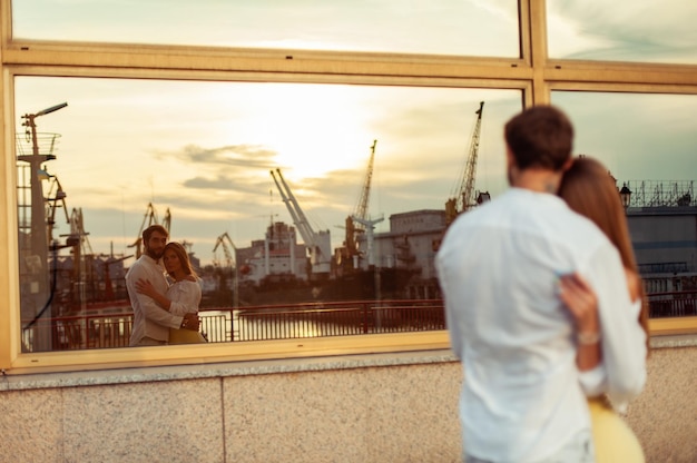 Foto jong verliefd koppel kijkt naar zichzelf in de weerspiegeling in het raam.