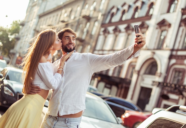 Foto jong verliefd koppel maakt selfie op smartphone in de stad romantisch liefdesconcept