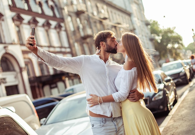 Foto jong verliefd koppel maakt selfie op smartphone in de stad romantisch liefdesconcept