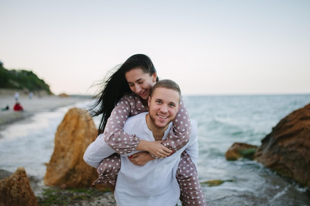 Jong verliefd stel Aantrekkelijke man en vrouw genieten van een romantische avond op het strand en kijken naar de zonsondergang