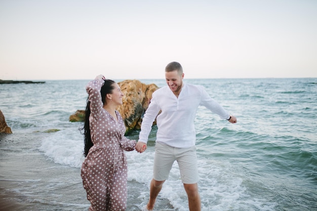 Jong verliefd stel Aantrekkelijke man en vrouw genieten van een romantische avond op het strand en kijken naar de zonsondergang