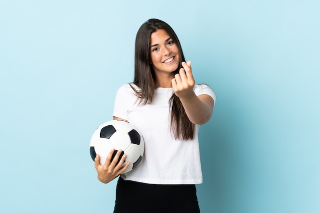 Jong voetballer Braziliaans meisje dat op blauw wordt geïsoleerd dat geldgebaar maakt