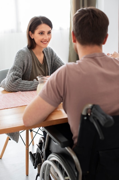 Foto jong volwassen eten met gehandicapte vriend