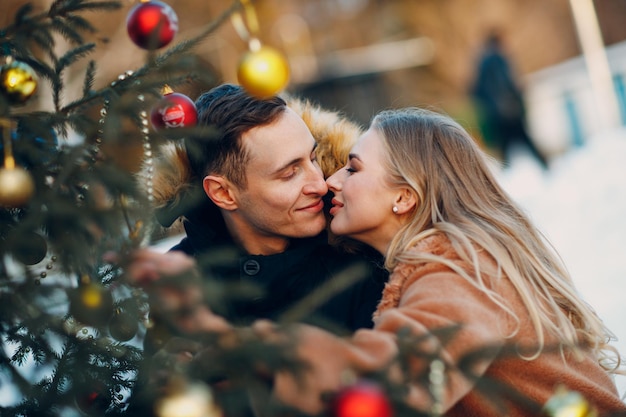 Jong volwassen koppel versiert kerstboom in winterbos nieuwjaar pine vakantie feest viering concept