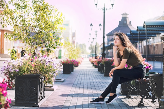 Foto jong volwassen mooi donkerbruin meisje in vrijetijdskleding gelukkig op stadsstraat