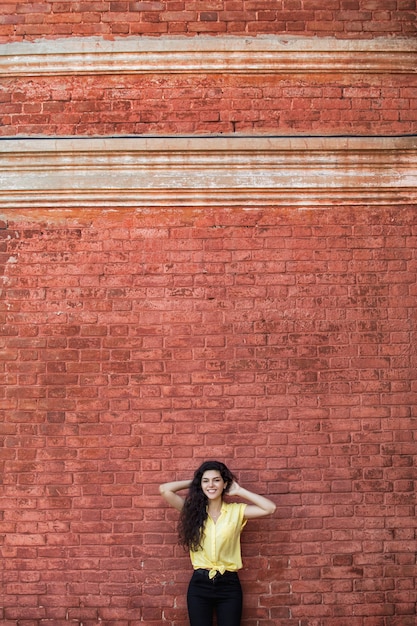 Foto jong volwassen mooi donkerbruin meisje in vrijetijdskleding op de achtergrond van een gebouw