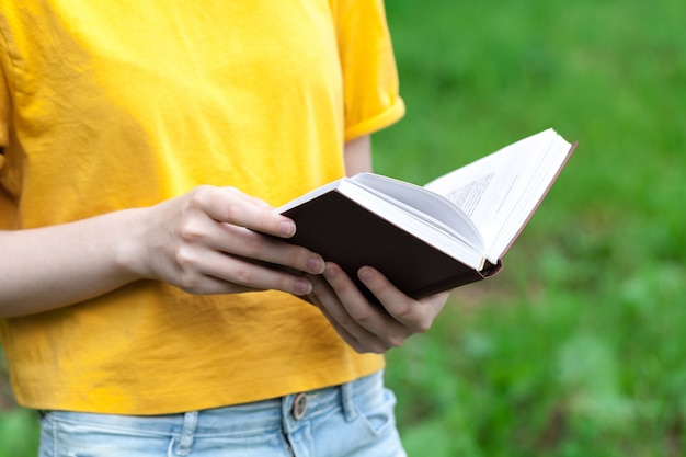 Jong vrouwelijk lezingsboek in de zomerpark