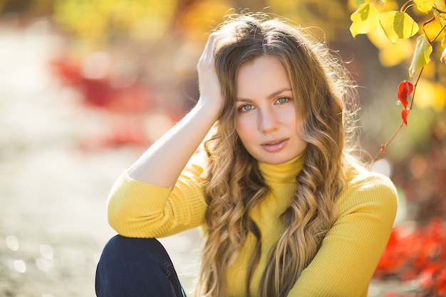 Jonge aantrekkelijke blonde vrouw in openlucht op dalingsachtergrond. Herfst portret van mooie stijlvolle vrouw.