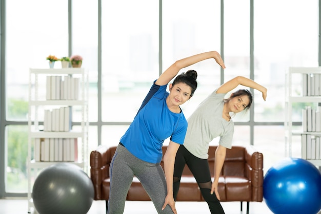 Jonge aantrekkelijke glimlachende vrouw die yoga beoefent die uitwerkt, sportkleding draagt, kalmte en ontspant, vrouwelijk geluk.