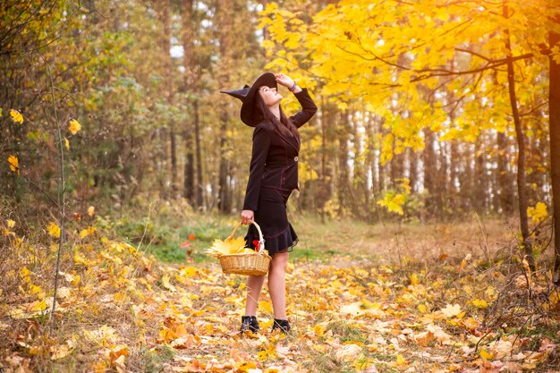 jonge aantrekkelijke heks loopt in de herfst oranje forest.helloween concept.