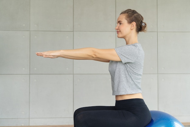 Jonge aantrekkelijke lachende vrouw beoefenen van yoga uit te werken, het dragen van sportkleding